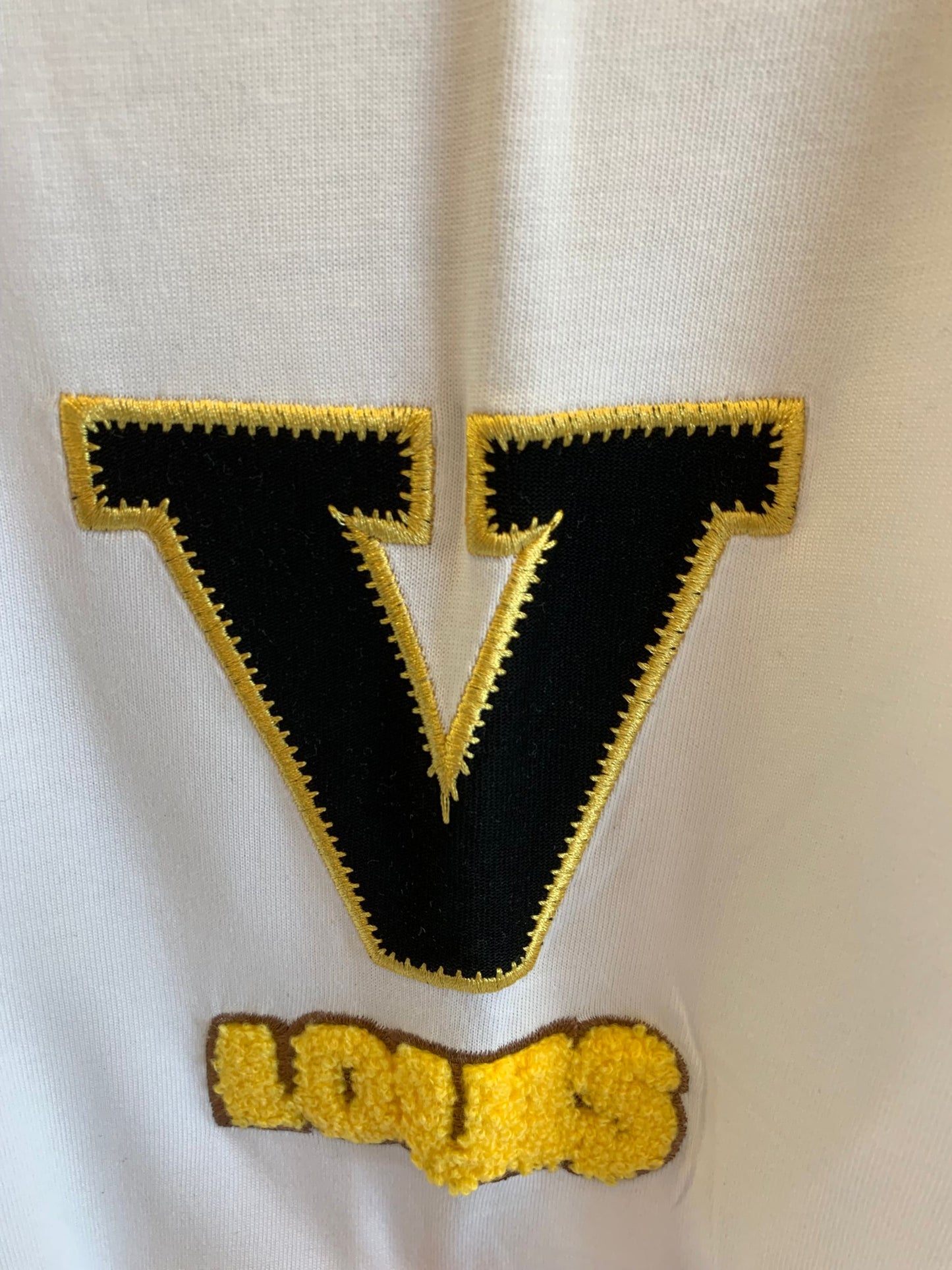 Camiseta blanca Louis Vuitton con detalle de cadena dorada y logotipo bordado
