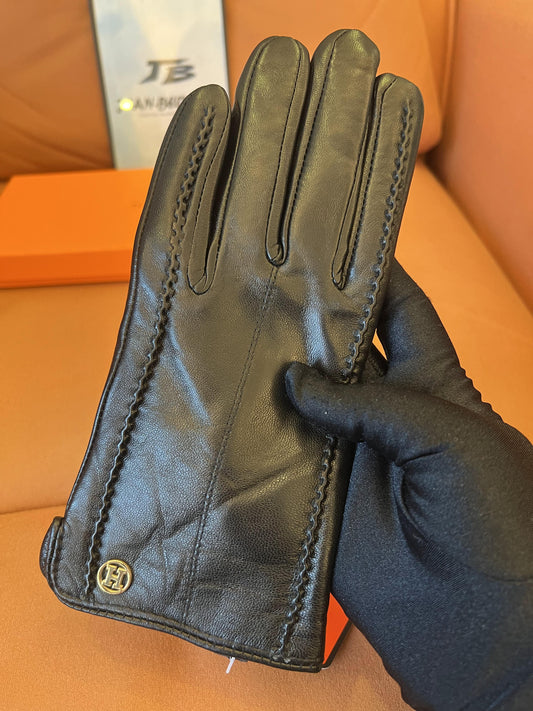 Guantes Hermès de piel negra: elegante piel de cordero con el logo H dorado.