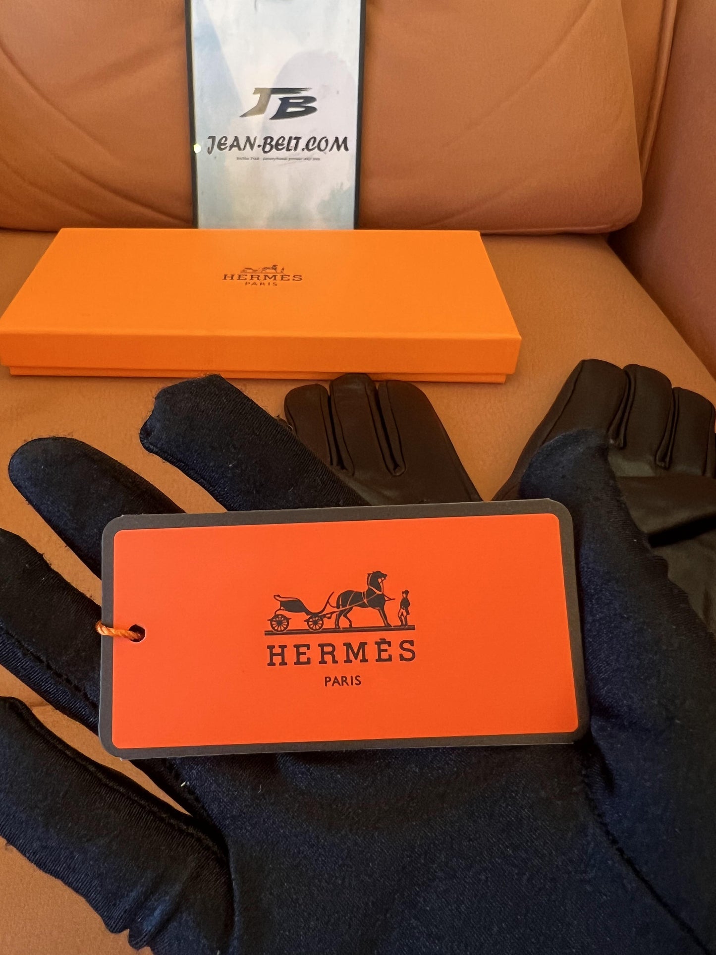 Guantes Hermès de piel negra: elegante piel de cordero con el logo H dorado.