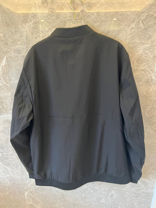 Chaqueta bomber de nailon negra de Hermès con parche del logotipo "H" amarillo.