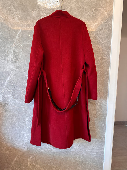 Abrigo de lana roja Hermes con cuello asimétrico y hebilla de cuero.