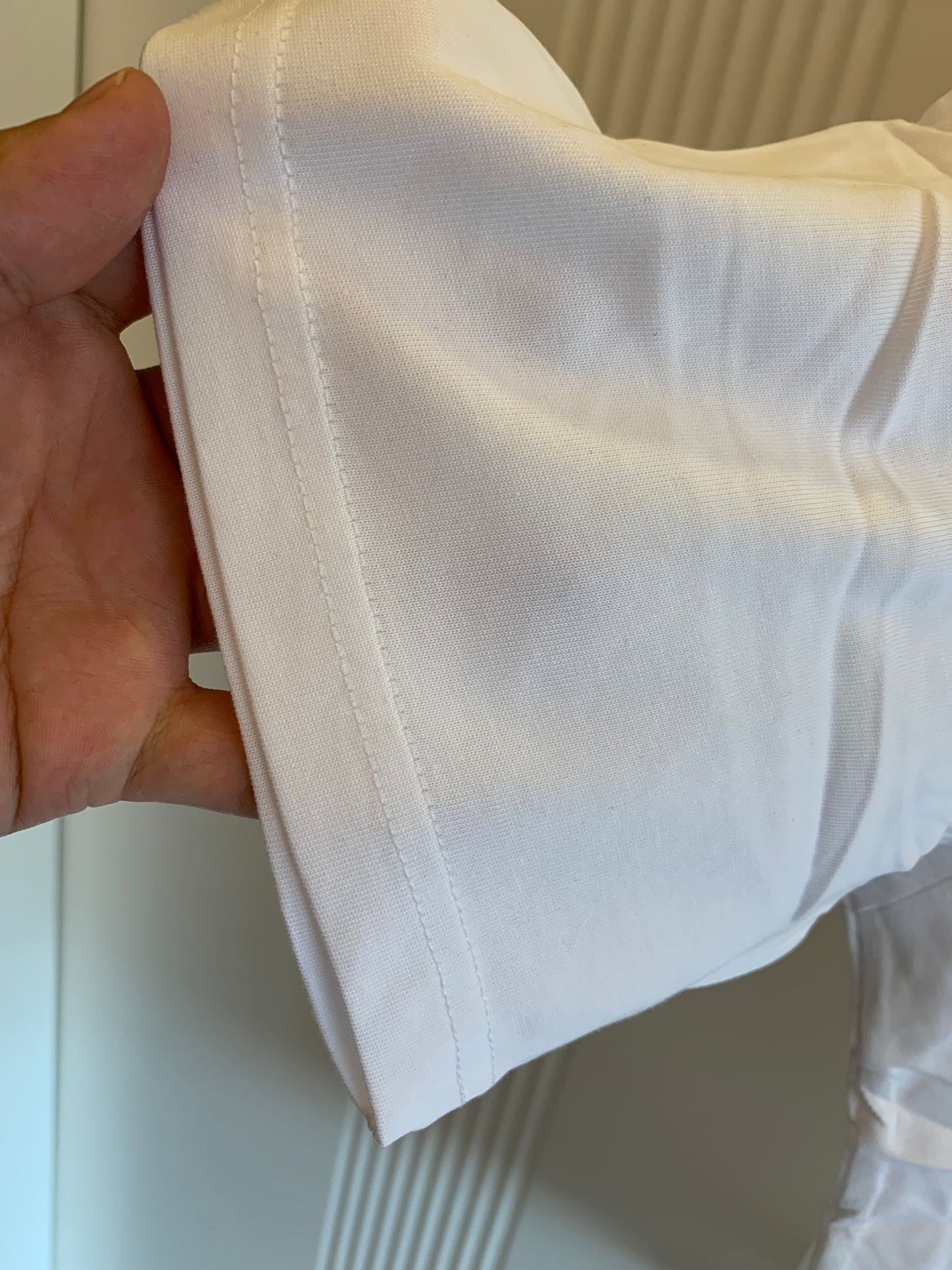 Camiseta blanca Louis Vuitton con detalle de cadena dorada y logotipo bordado