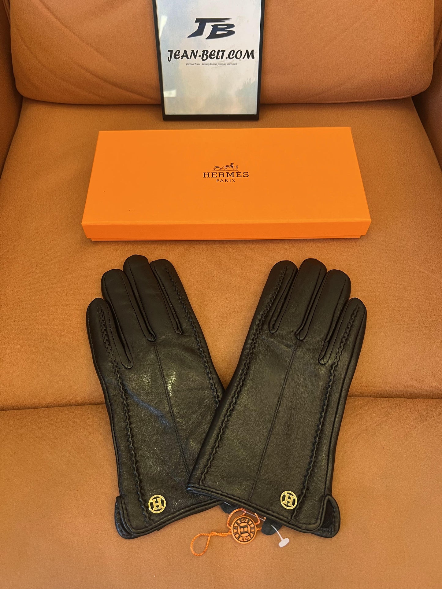 Guantes Hermès de piel negra: elegante piel de cordero con el logo H dorado.