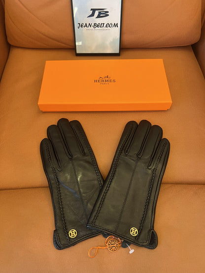 Guantes Hermès de piel negra: elegante piel de cordero con el logo H dorado.