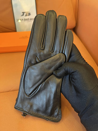 Guantes Hermès de piel negra: elegante piel de cordero con el logo H dorado.