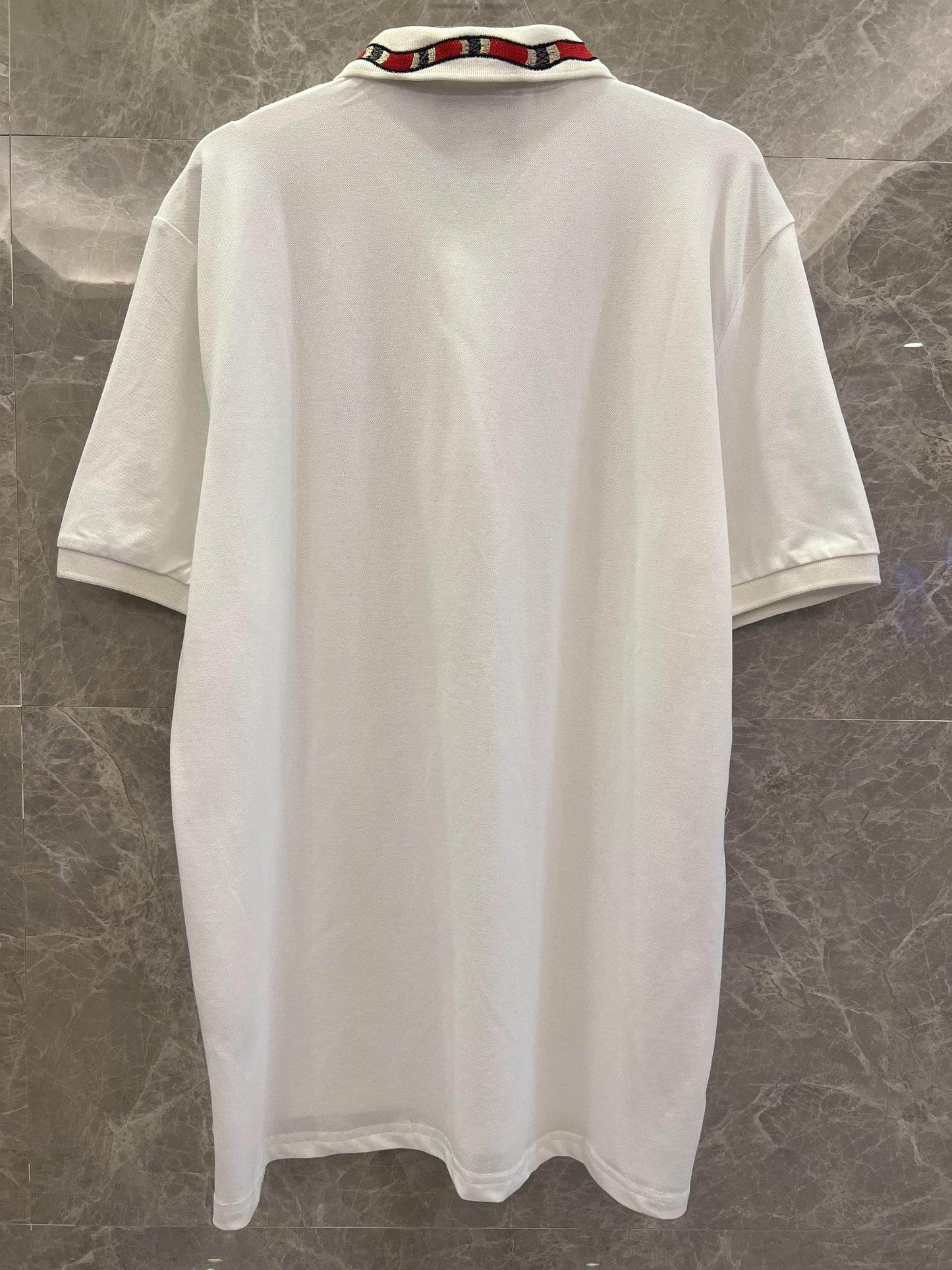 Polo blanco Gucci con cuello bordado de serpiente