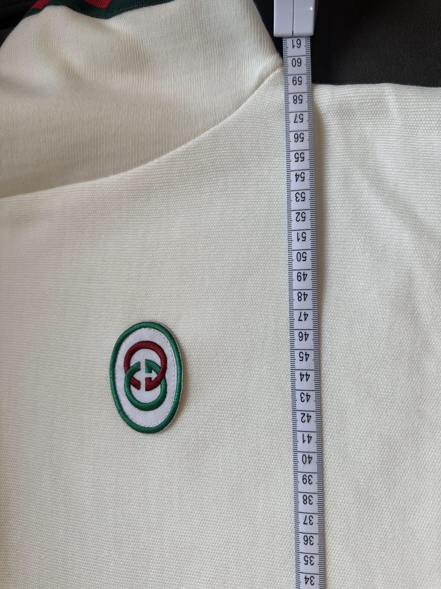 Suéter blanco de cuello alto con el logotipo de Gucci y rayas distintivas
