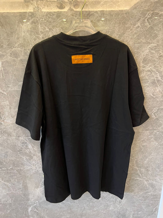 Camiseta negra de Louis Vuitton con el gráfico "The Louis Vuittons" y una etiqueta naranja de París.
