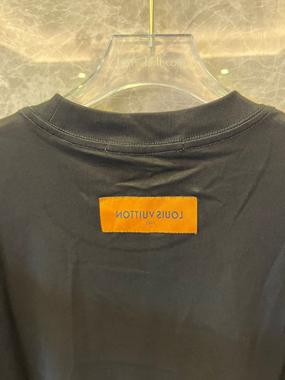 Camiseta negra de Louis Vuitton con el gráfico "The Louis Vuittons" y una etiqueta naranja de París.