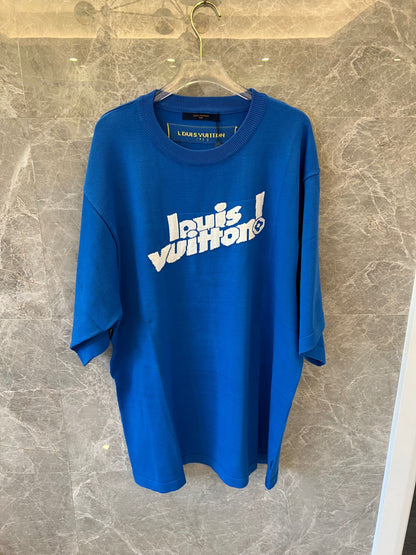 Camiseta azul Louis Vuitton com logotipo "Louis Vuitton!" na frente e etiqueta amarela Paris