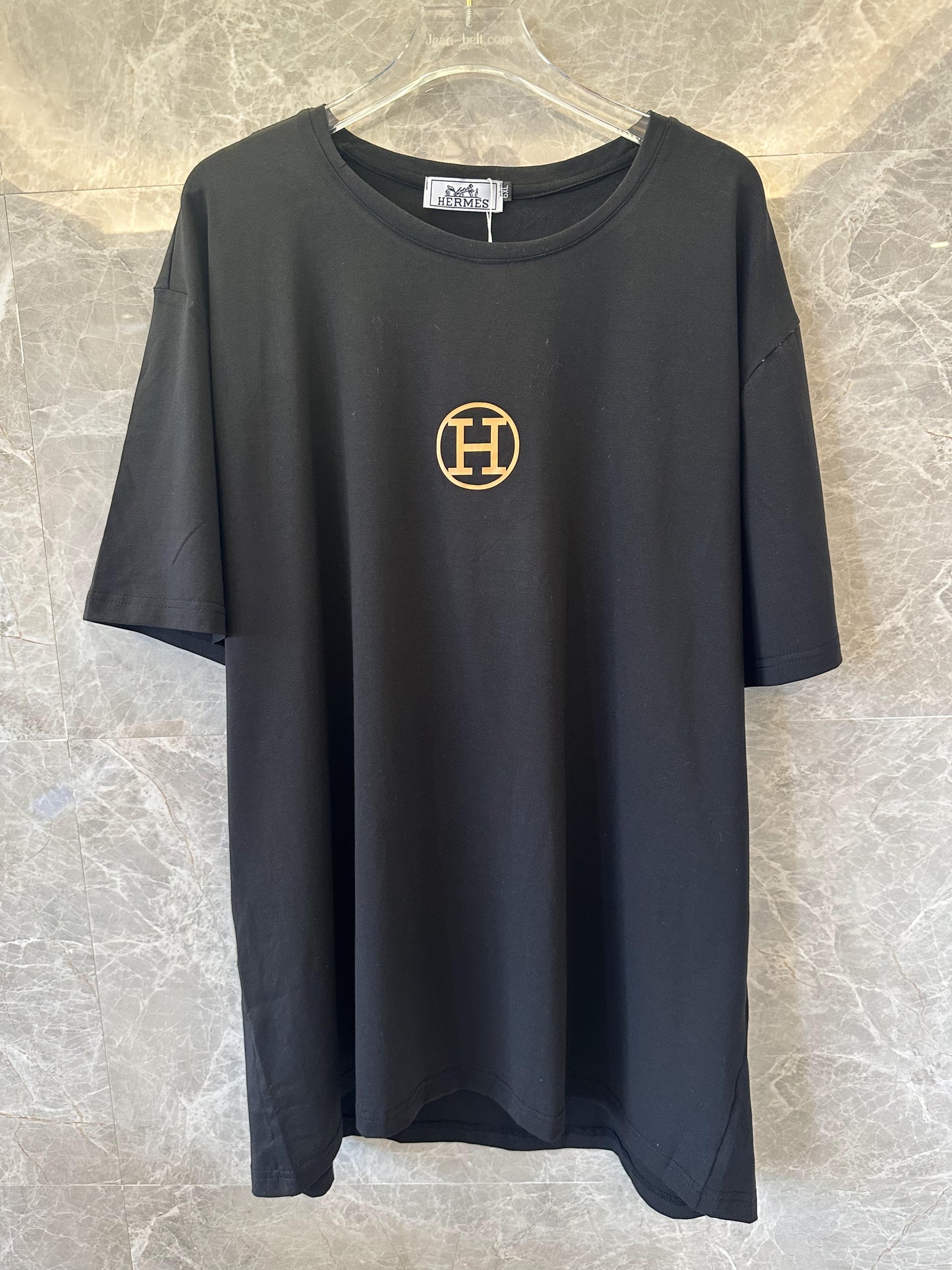 Camiseta preta Hermès com logotipo e marca dourados