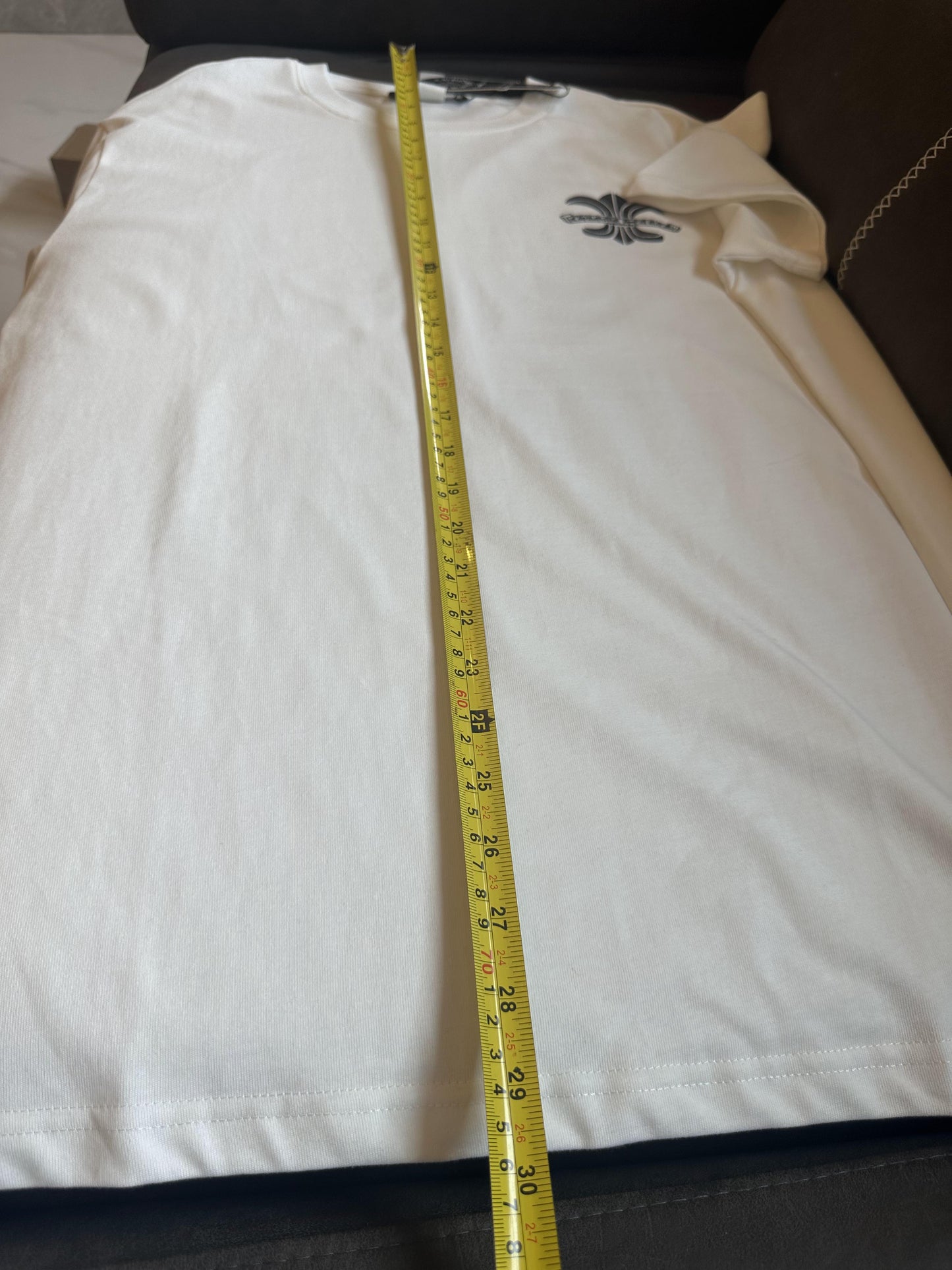 Camiseta branca Chrome Hearts com logotipo preto e design decorativo nas costas