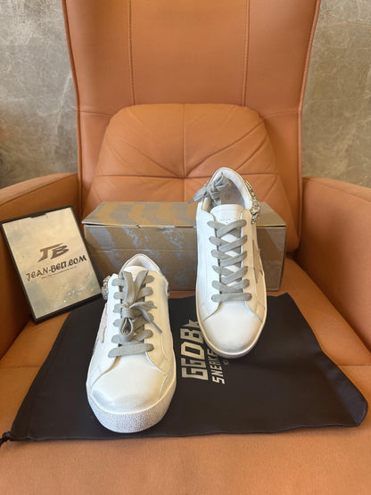 Zapatos viejos blancos con estrella de ganso dorado y diamantes