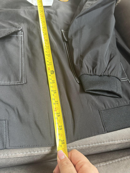 Chaqueta bomber de nailon negra de Hermès con parche del logotipo "H" amarillo.