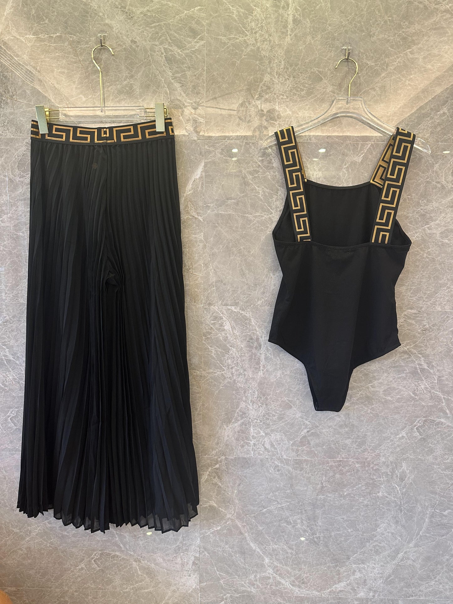 Conjunto de falda plisada y body negro con ribete de greca de Versace