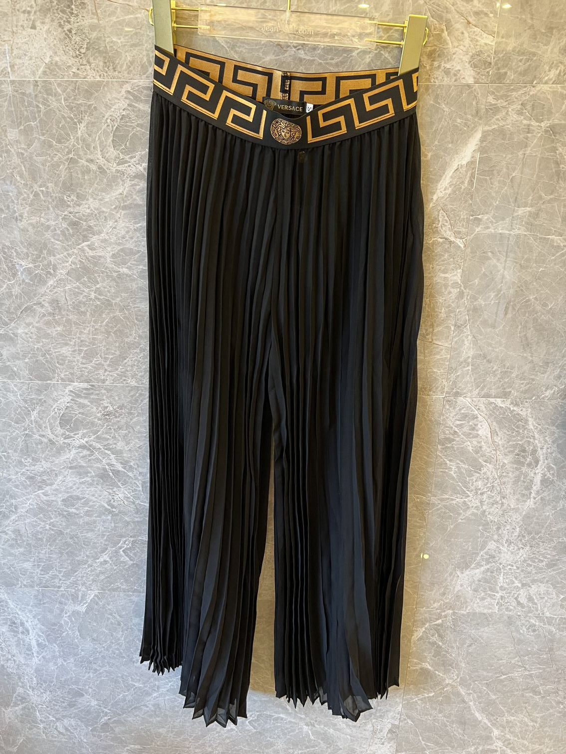 Conjunto de falda plisada y body negro con ribete de greca de Versace