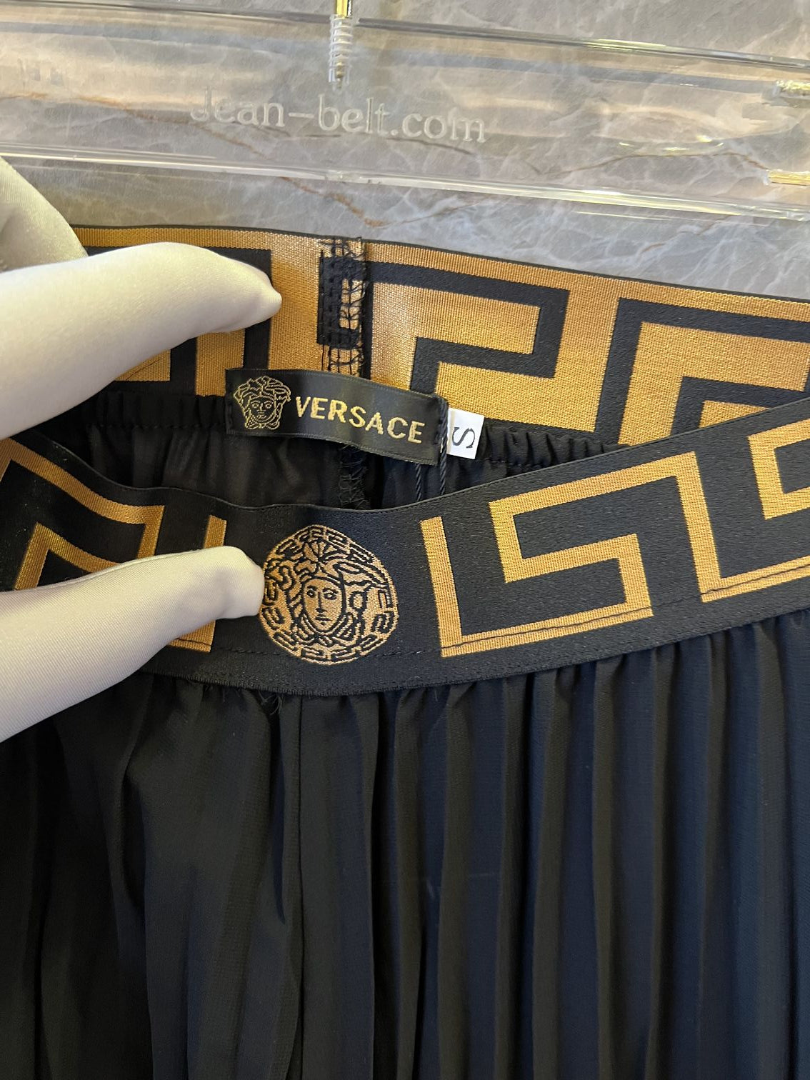 Conjunto de falda plisada y body negro con ribete de greca de Versace