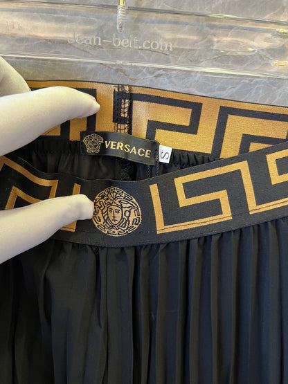 Conjunto de falda plisada y body negro con ribete de greca de Versace