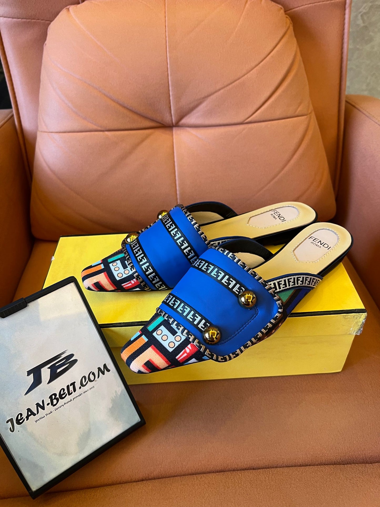 Sandalias azules tipo slide para mujer de Fendi con tiras estampadas y detalles dorados.