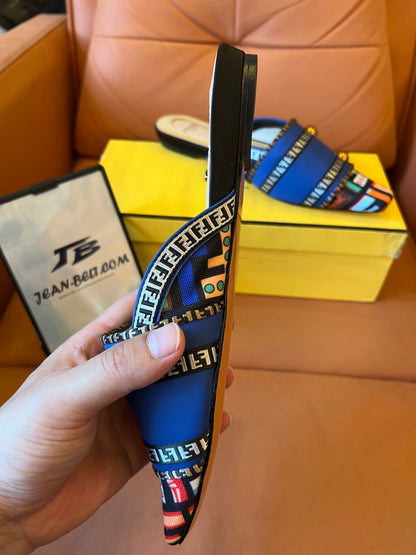 Sandalias azules tipo slide para mujer de Fendi con tiras estampadas y detalles dorados.