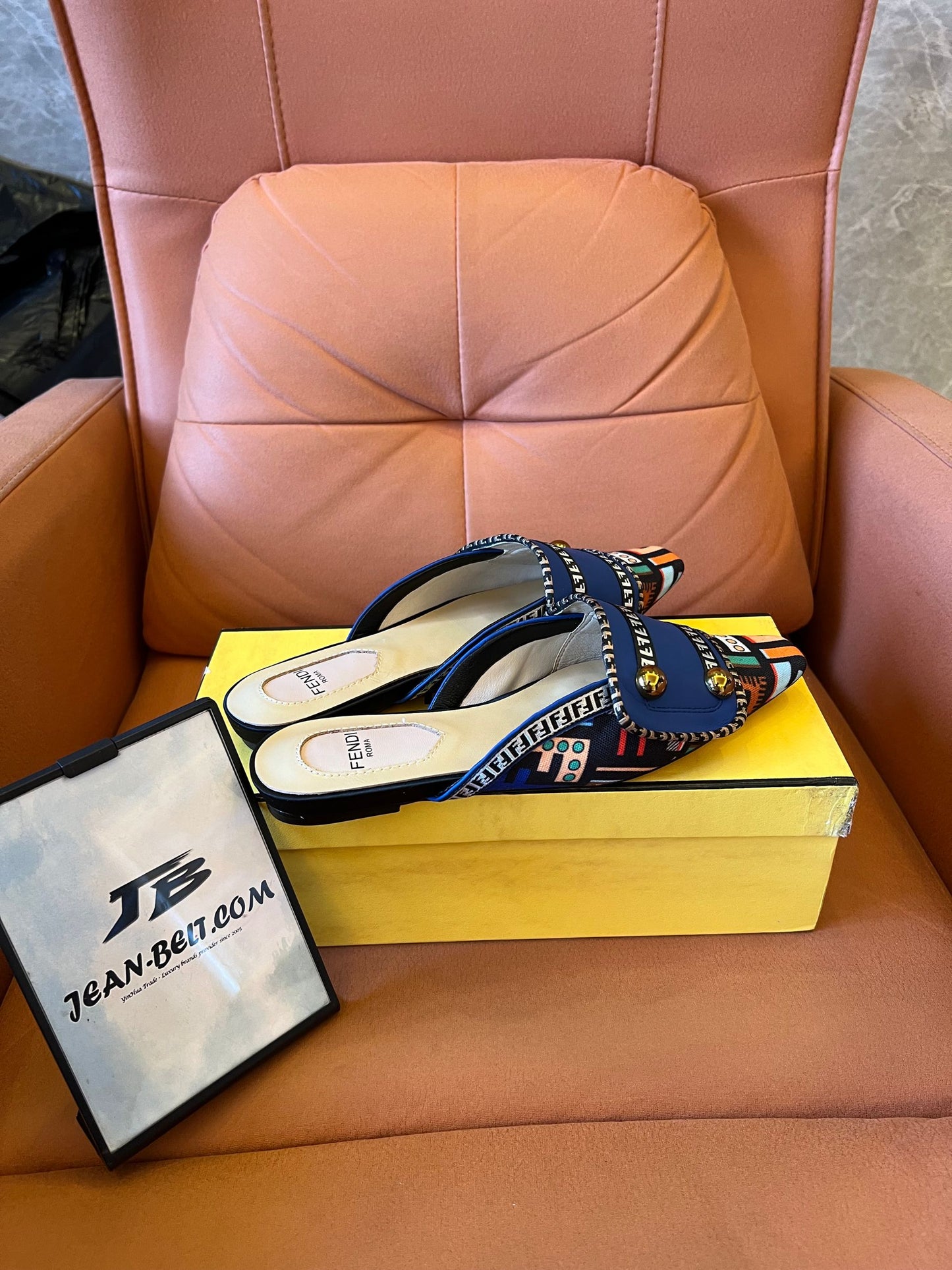 Sandalias azules tipo slide para mujer de Fendi con tiras estampadas y detalles dorados.