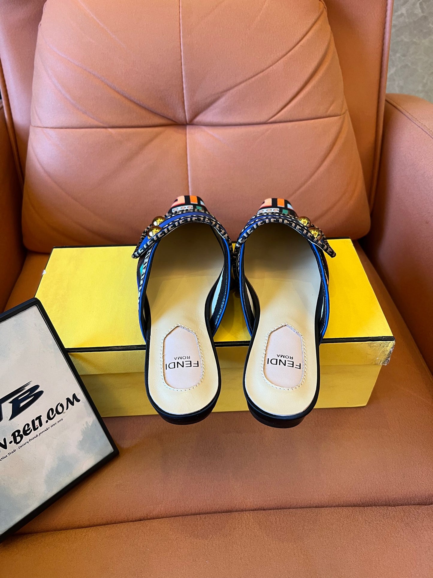 Sandalias azules tipo slide para mujer de Fendi con tiras estampadas y detalles dorados.