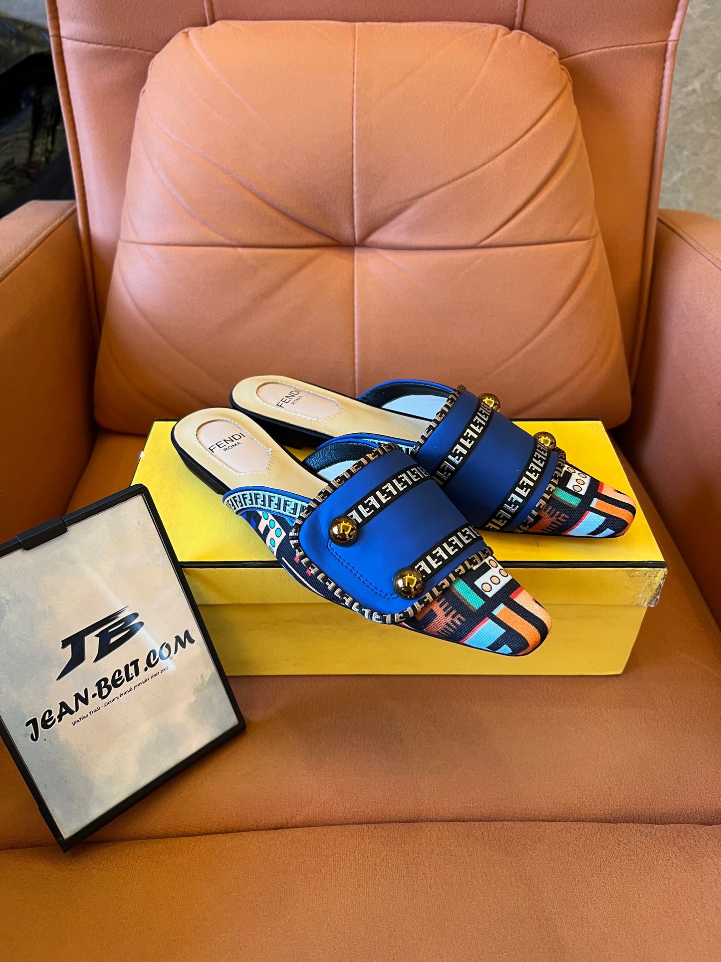 Sandalias azules tipo slide para mujer de Fendi con tiras estampadas y detalles dorados.