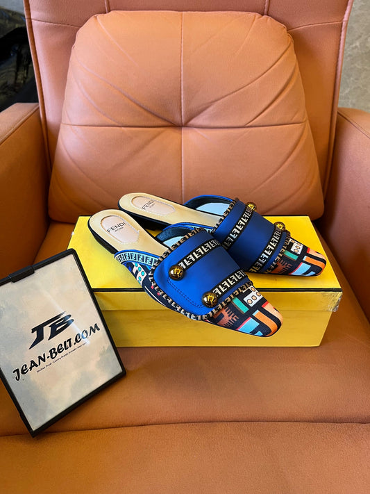 Sandalias azules tipo slide para mujer de Fendi con tiras estampadas y detalles dorados.