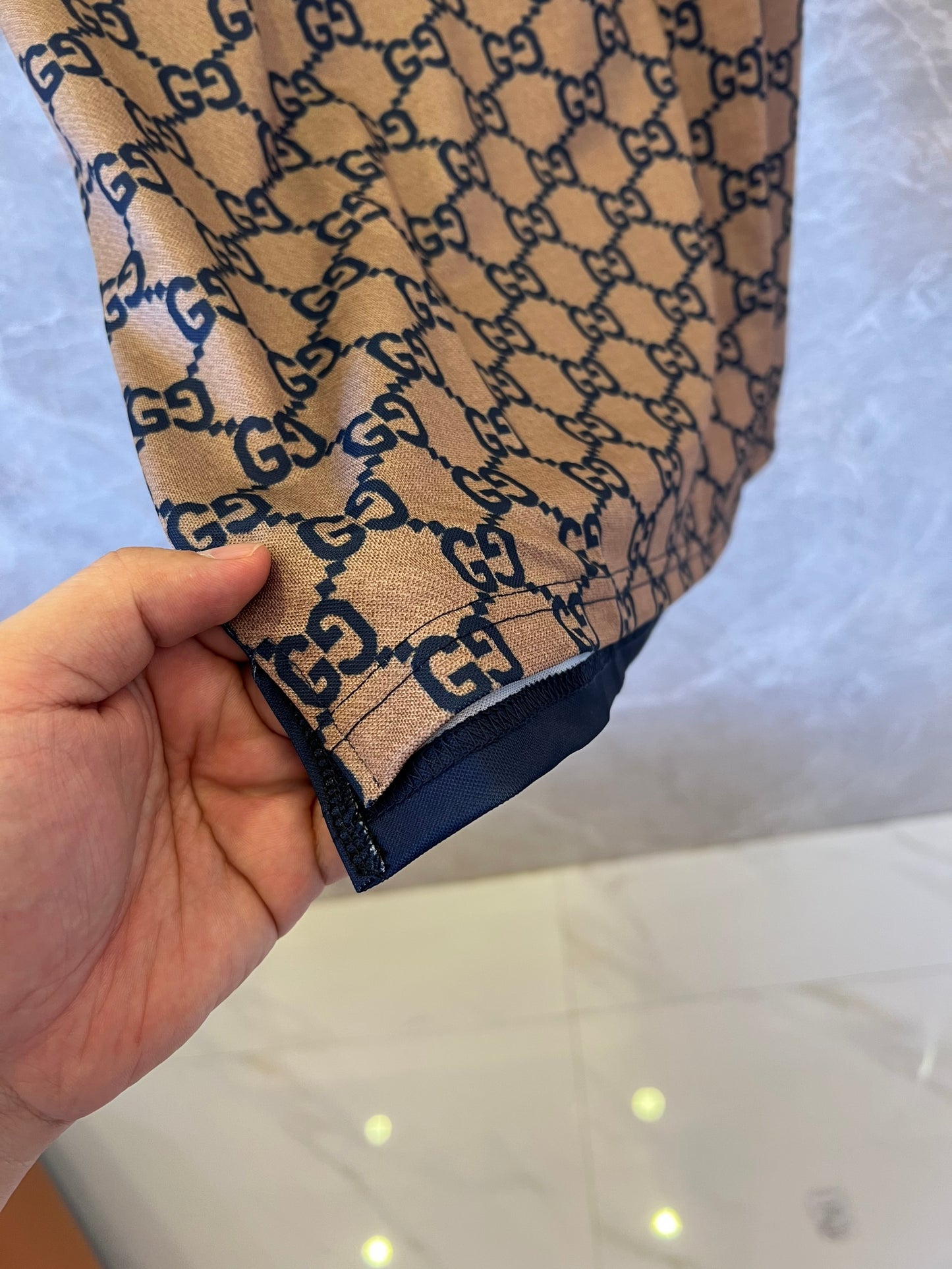 Camisa polo bege e azul marinho com monograma Gucci e estampa GG