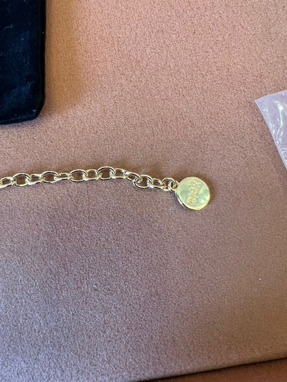 Pulsera de cadena dorada Dior con el icónico CD y charms de corazón