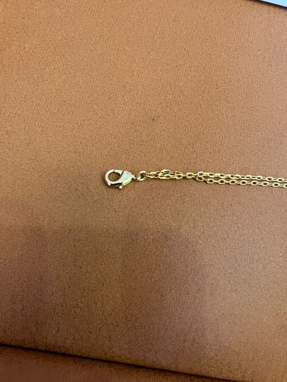 Pulsera de cadena dorada Dior con el icónico CD y charms de corazón