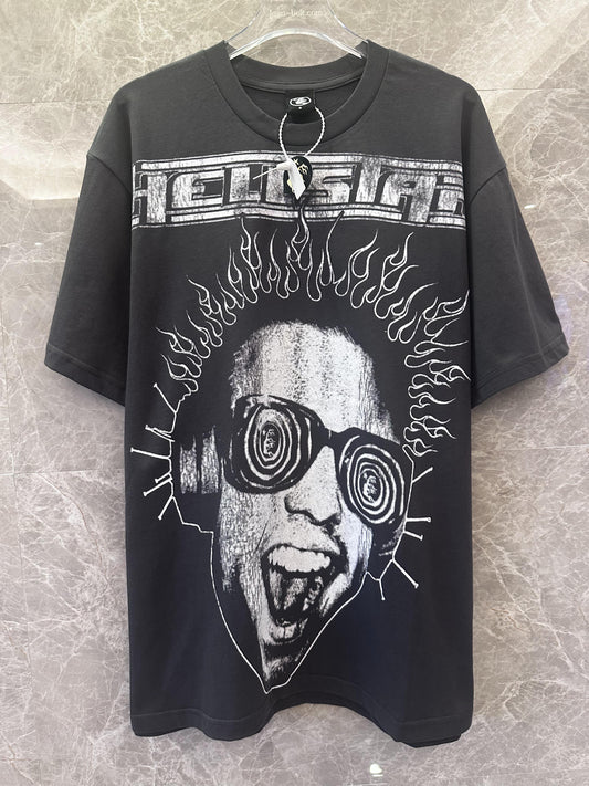 Camiseta gráfica negra de glamour histérico con estampado de cara psicodélica y texto.