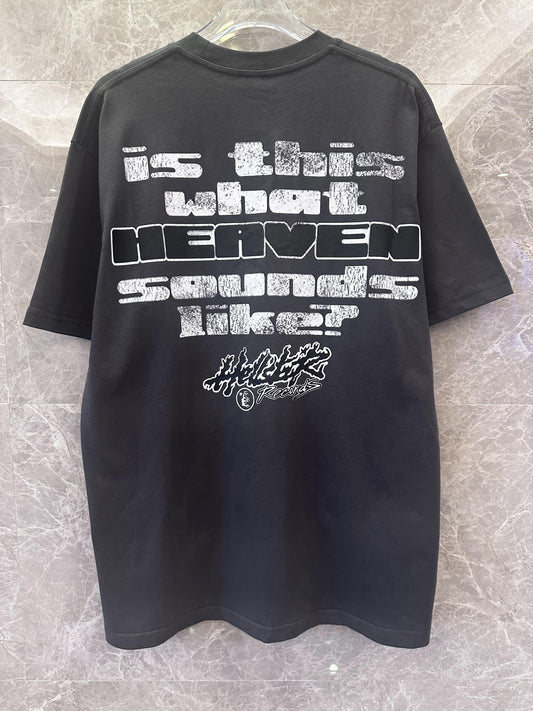 Camiseta gráfica negra de glamour histérico con estampado de cara psicodélica y texto.