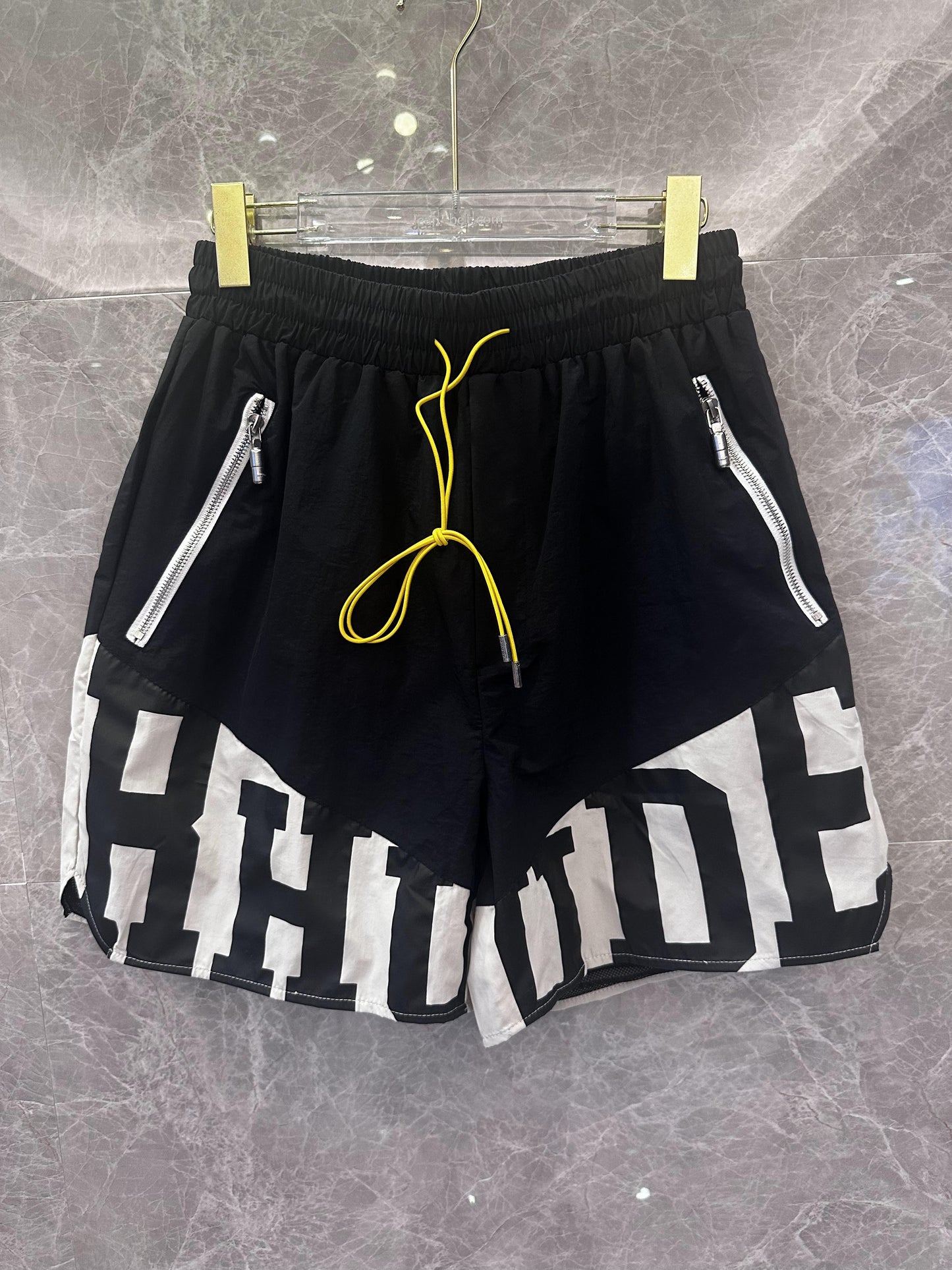 Rhude black and white logo shorts with yellow drawstring and zipper detail