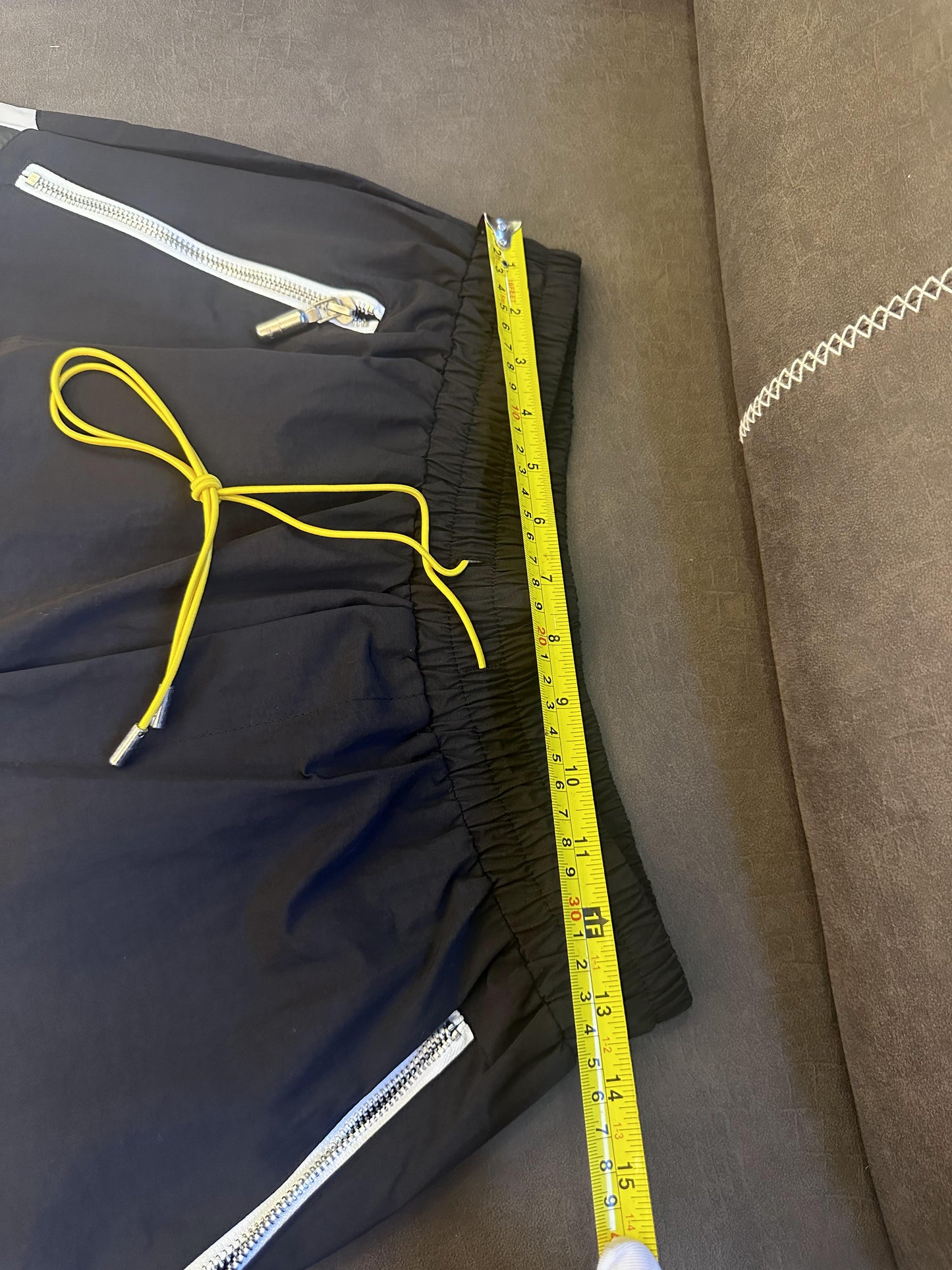 Rhude black and white logo shorts with yellow drawstring and zipper detail