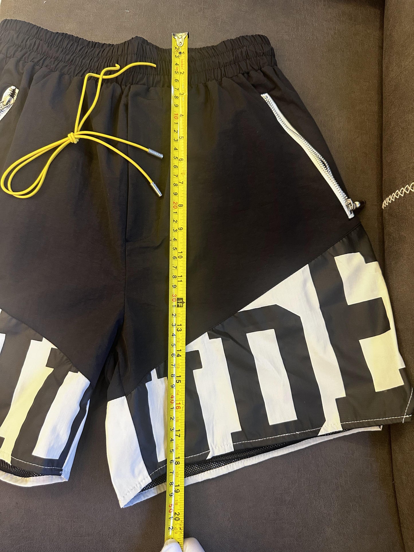 Rhude black and white logo shorts with yellow drawstring and zipper detail
