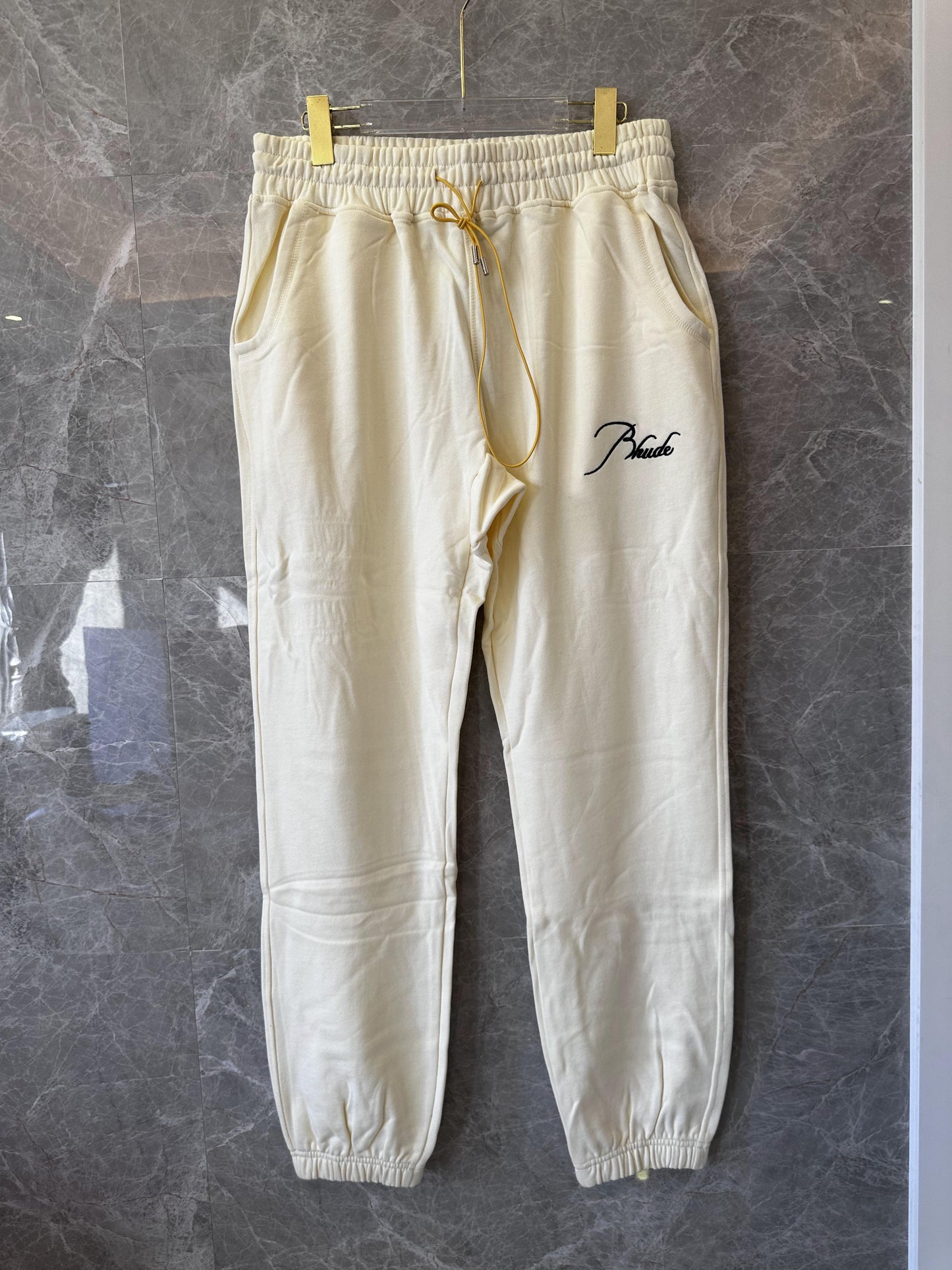 Conjunto de chándal Rhude color crema con bordado característico