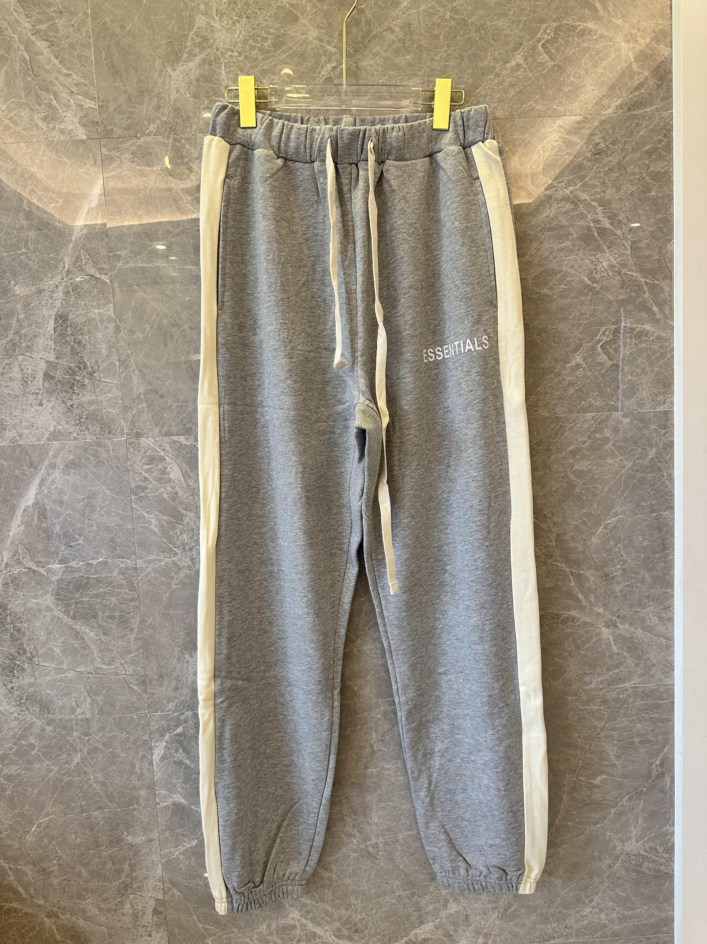 Pantalones deportivos grises Essentials con raya lateral color marfil