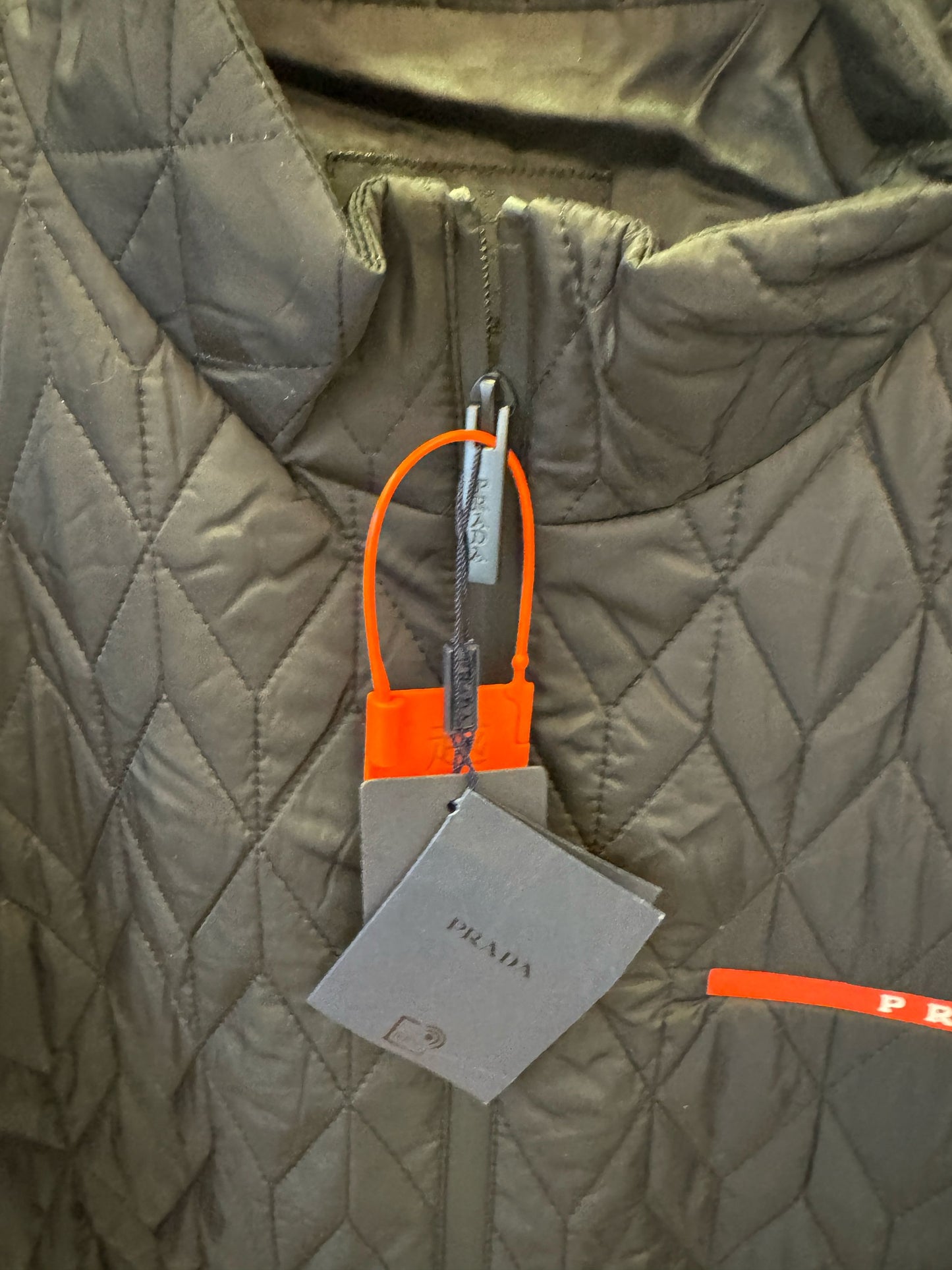 Chaqueta acolchada negra de Prada con detalle de logotipo rojo