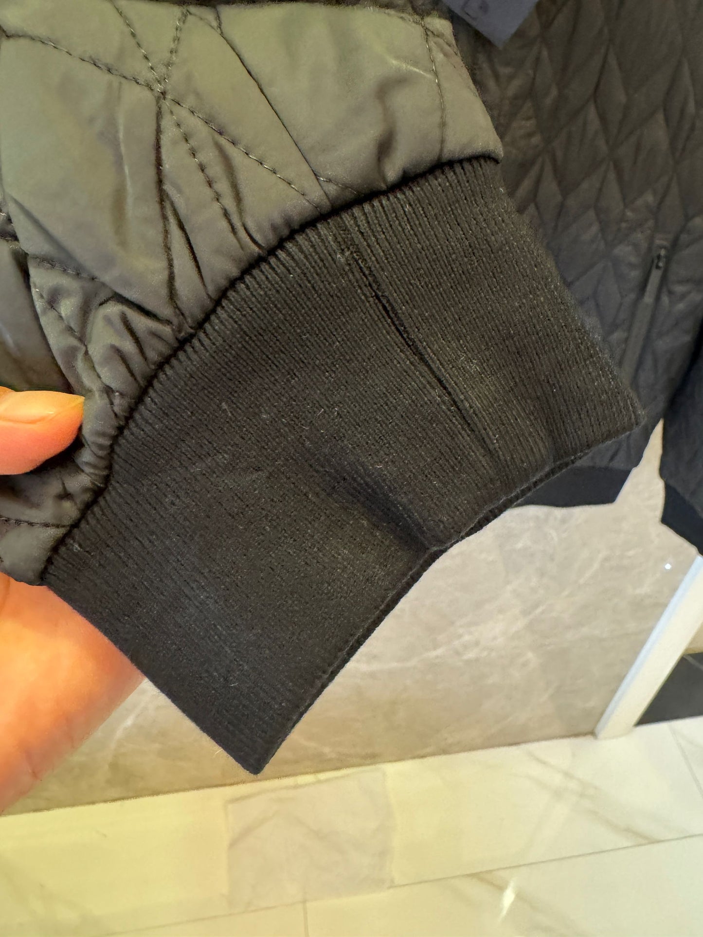 Chaqueta acolchada negra de Prada con detalle de logotipo rojo