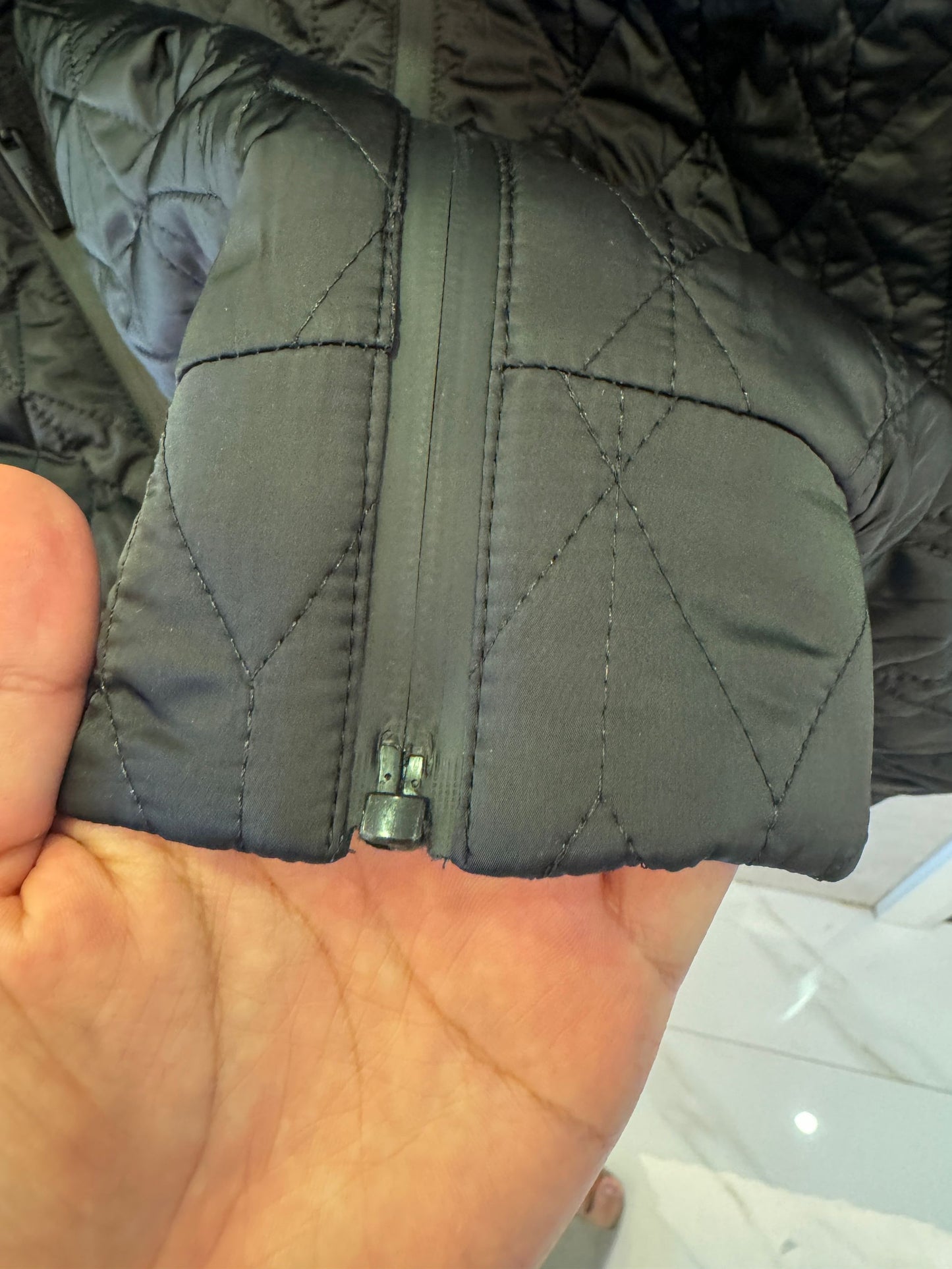 Chaqueta acolchada negra de Prada con detalle de logotipo rojo