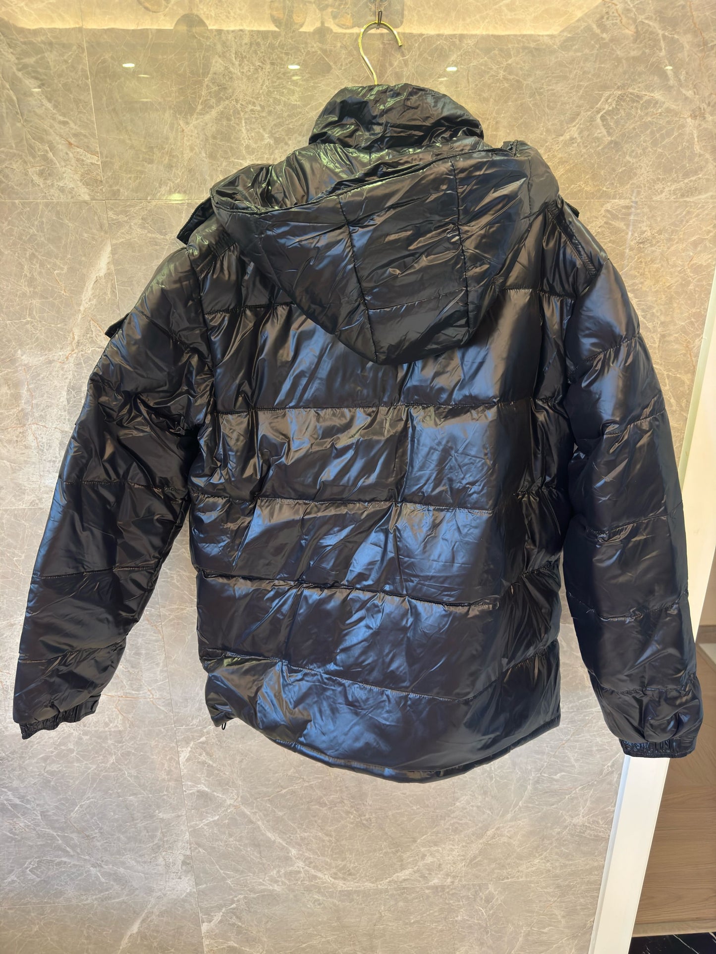 Chaqueta acolchada negra brillante de Prada con diseño de capucha