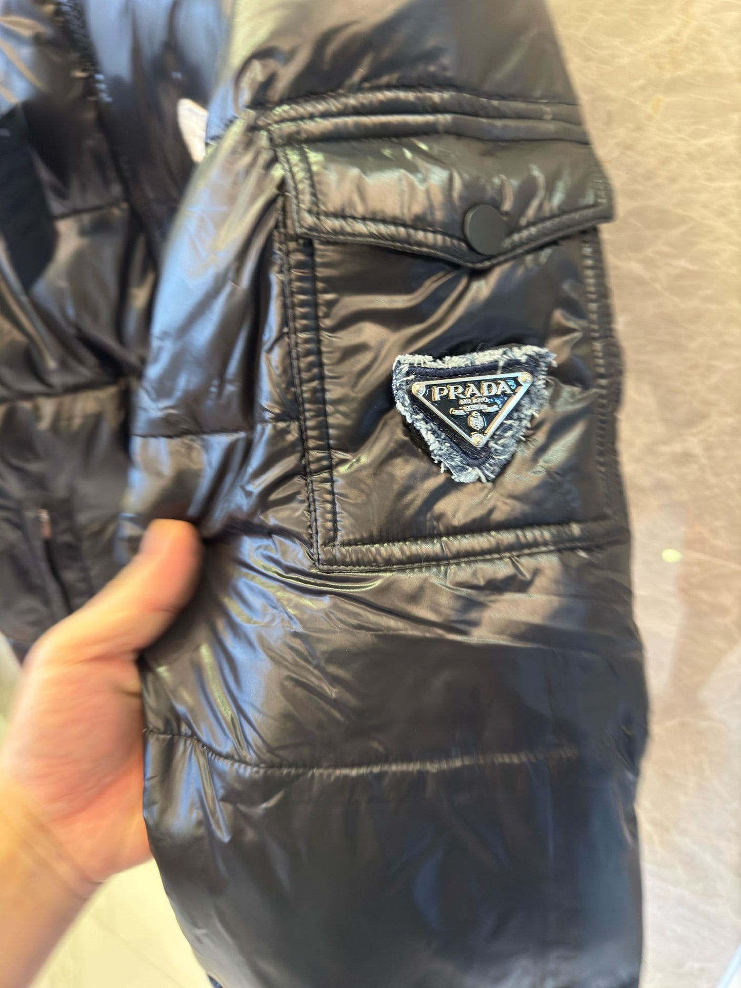 Chaqueta acolchada negra brillante de Prada con diseño de capucha