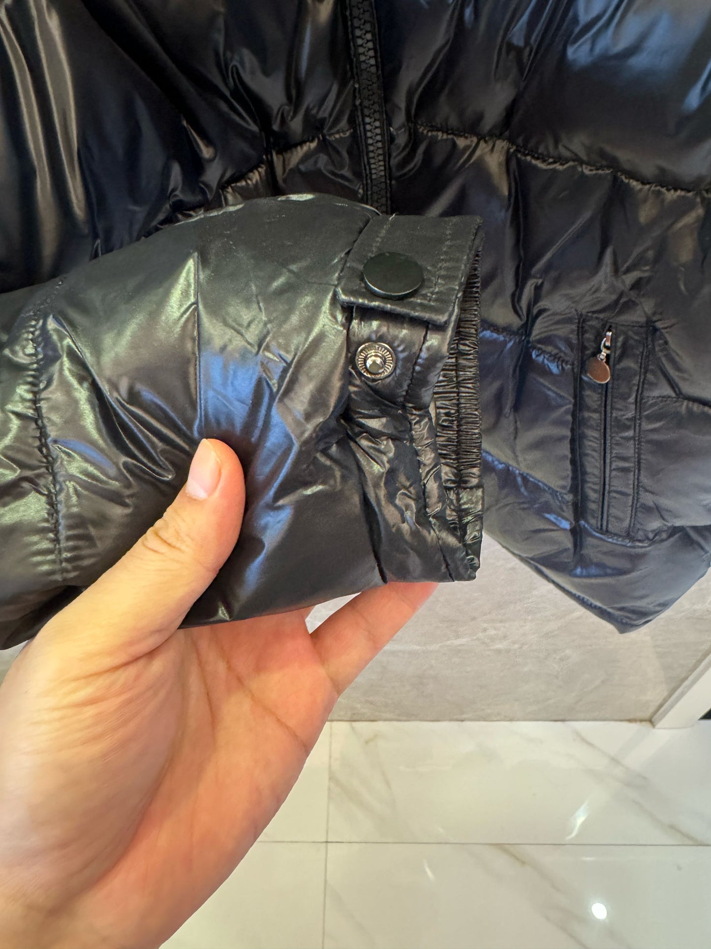 Chaqueta acolchada negra brillante de Prada con diseño de capucha