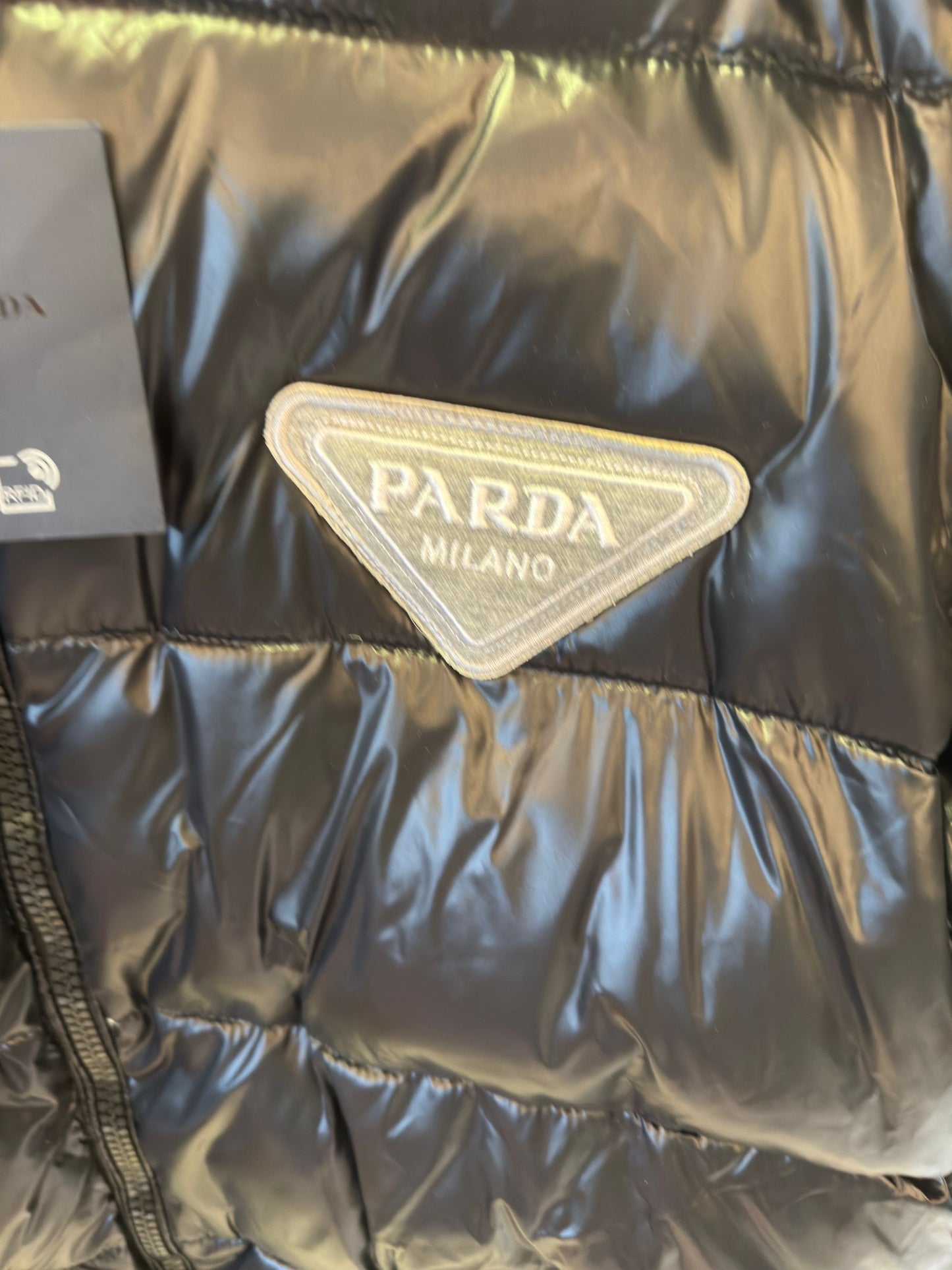 Chaqueta acolchada negra brillante de Prada con diseño de capucha