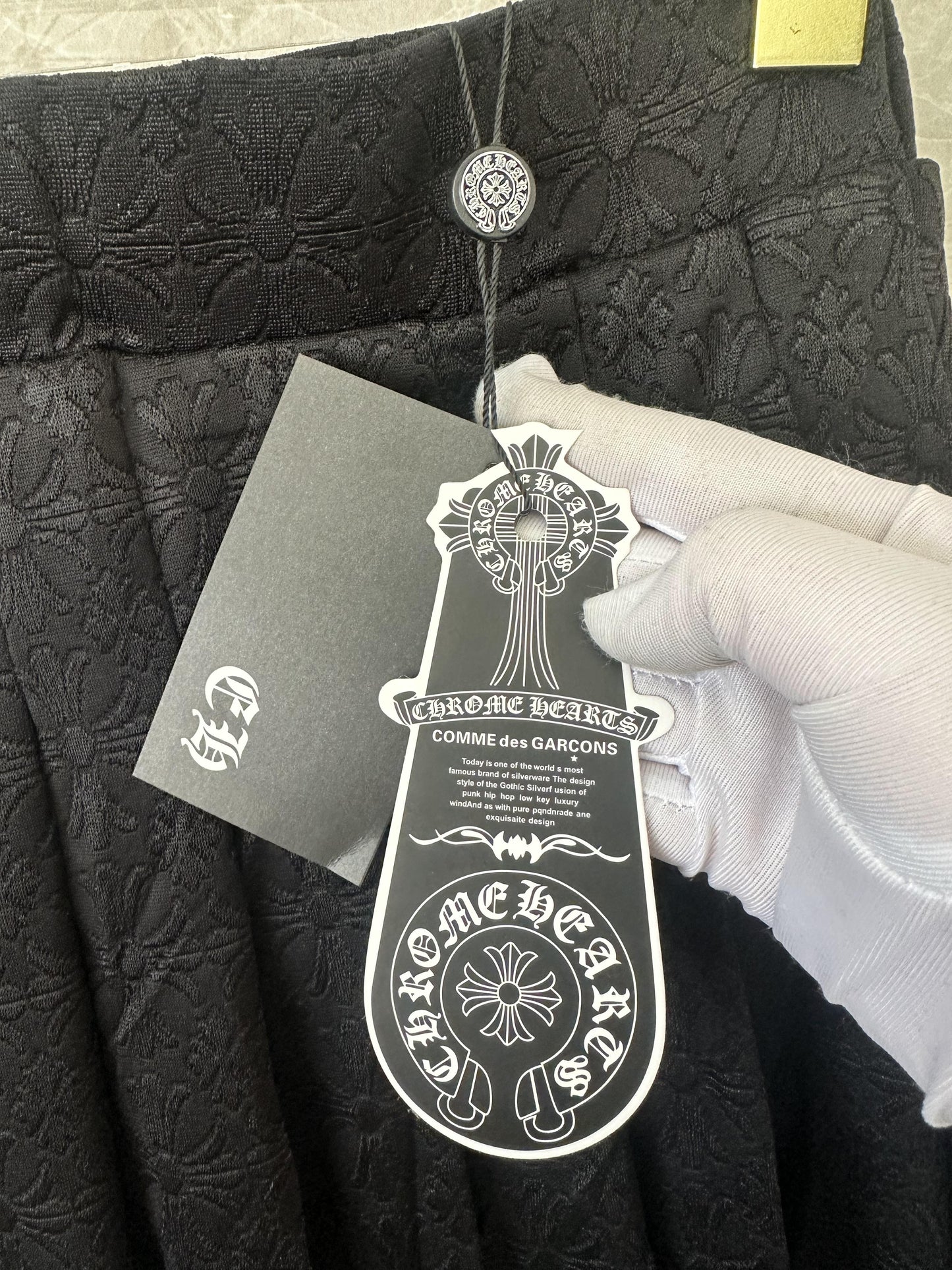 Conjunto de top corto tipo polo bordado negro y minifalda plisada de Chrome Hearts
