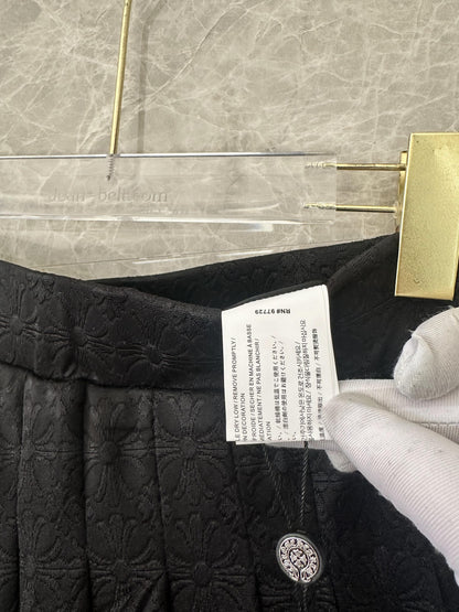 Conjunto de top corto tipo polo bordado negro y minifalda plisada de Chrome Hearts