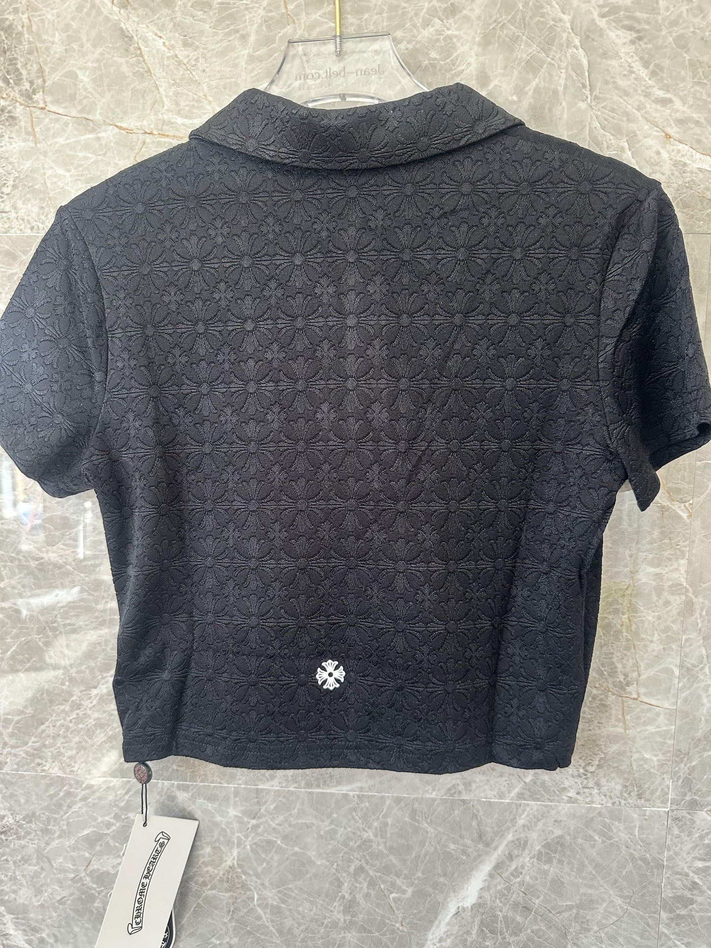 Conjunto de top corto tipo polo bordado negro y minifalda plisada de Chrome Hearts