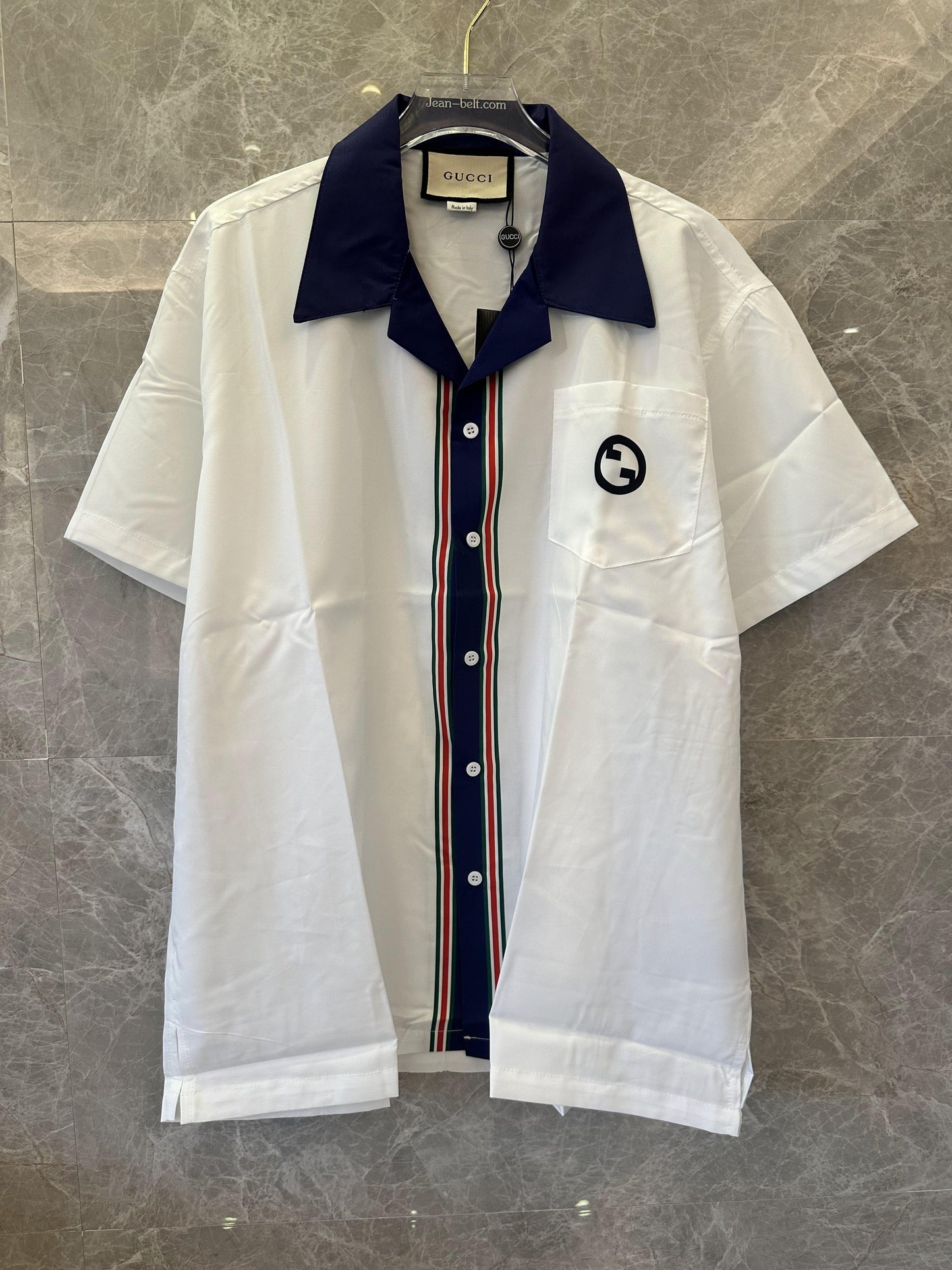 Camisa Gucci blanca de manga corta con botones, cuello azul marino y rayas.
