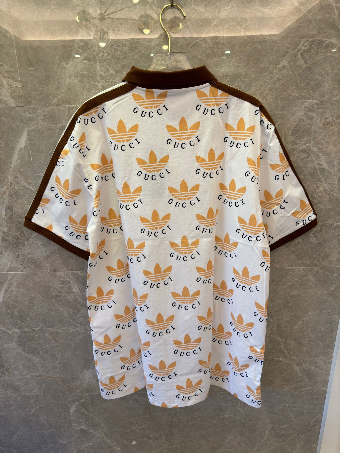 Polo con estampado de trébol de Gucci x Adidas en blanco y marrón con logotipos icónicos